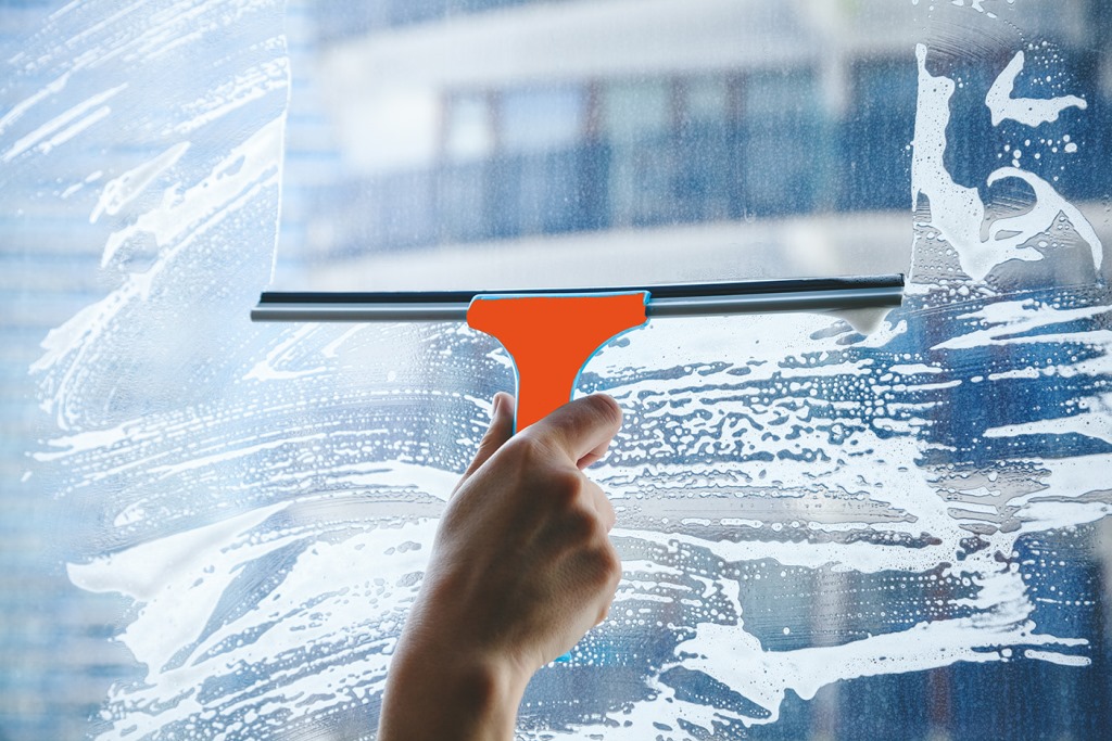 young female hand cleaning dirty glass window